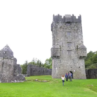The tower of Aughnanure Castle and the ruined hall beside it on the grass