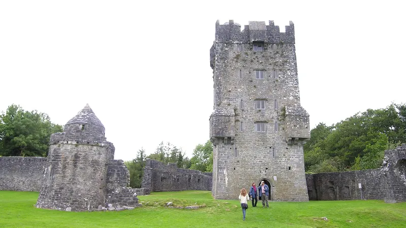 The tower of Aughnanure Castle and the ruined hall beside it on the grass