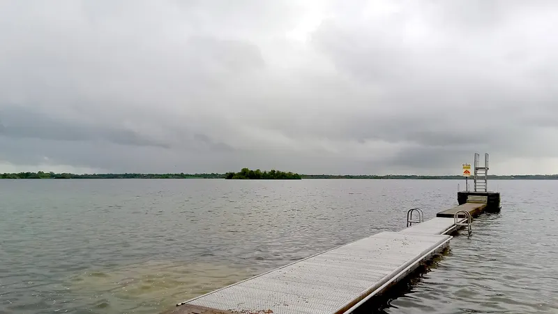A timber jetty running out into Lough Owel under a grey sky