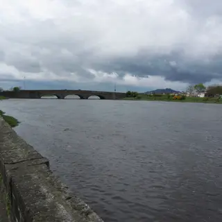 The river running under the long arched bridge at Dundalk on a grey day