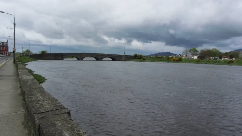 The river running under the long arched bridge at Dundalk on a grey day